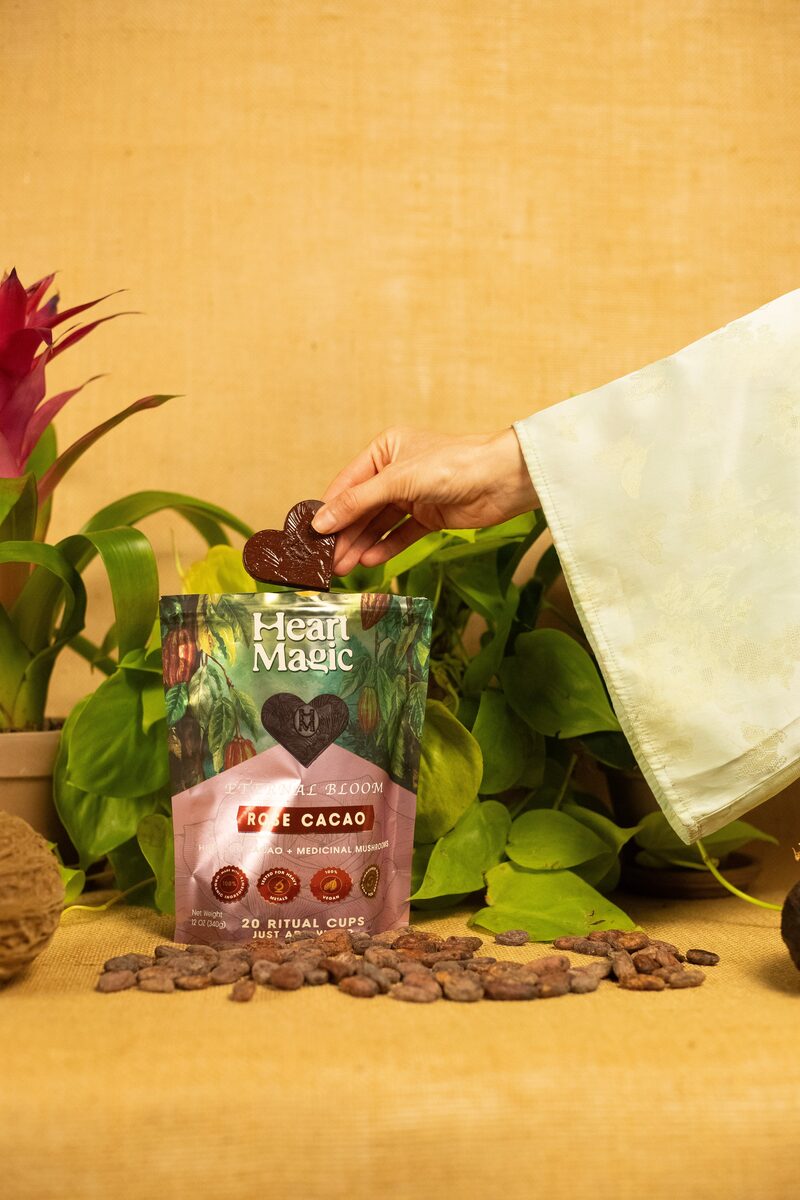 Hand picking up a Heart Magic cacao heart from an open pouch